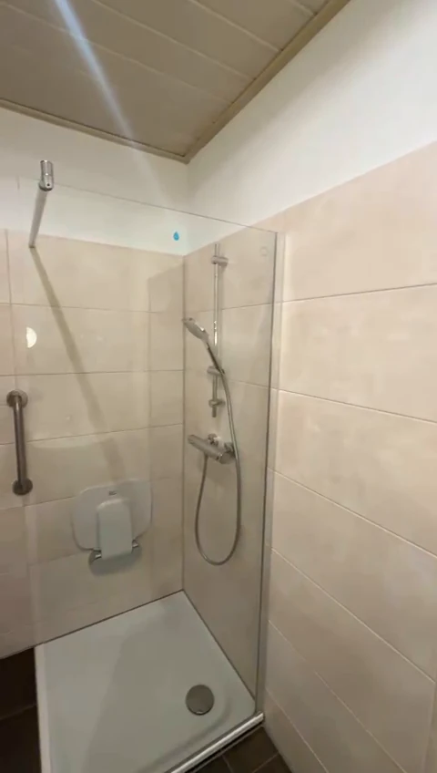 Neue Dusche mit Glasabtrennung und heller Wandfliese